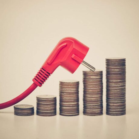 um fio de tomada vermelho em cima de uma "escadinha" de moedas