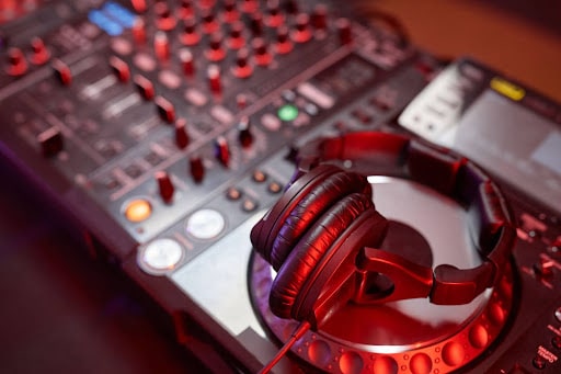 uma mesa de som de um dj e um fone de ouvido grande sobre ela