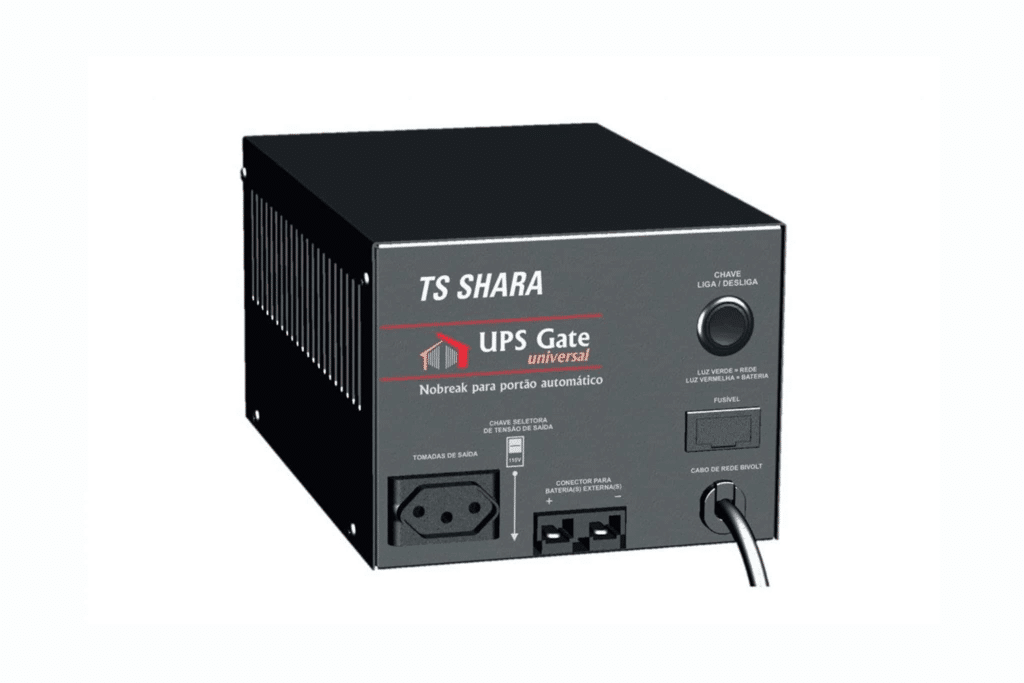 A imagem mostra um nobreak TS Shara modelo UPS Gate Universal. O dispositivo tem uma cor preta e apresenta várias portas e botões na parte frontal. Ele possui tomadas de saída para conectar equipamentos, um botão de liga/desliga (chave), e luzes indicadoras de status. Também é possível ver entradas para conexão de cabos, e o modelo é projetado para fornecer energia ininterrupta, sendo ideal para ambientes que necessitam de proteção elétrica. O design é simples e funcional, com um acabamento metálico.
