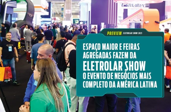 Foto de uma feira de tecnologia movimentada, com muitas pessoas caminhando entre estandes iluminados. Uma placa em destaque anuncia o evento Eletrolar Show, descrito como o maior e mais completo evento de negócios da América Latina