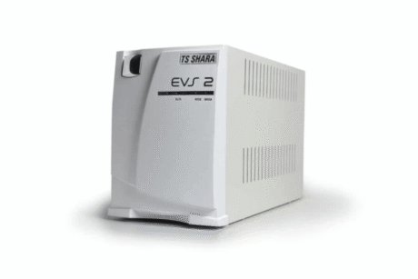 A imagem apresenta um nobreak TS Shara modelo EVS 2, que é um sistema de alimentação ininterrupta. O dispositivo tem um design branco, com um acabamento limpo e simples. O modelo possui entradas e saídas para fornecer energia de emergência, com uma tampa frontal que inclui a marca TS Shara e a inscrição "EVS 2". O nobreak é projetado para oferecer proteção contra falhas de energia, mantendo os dispositivos conectados operacionais durante quedas ou oscilações de energia.